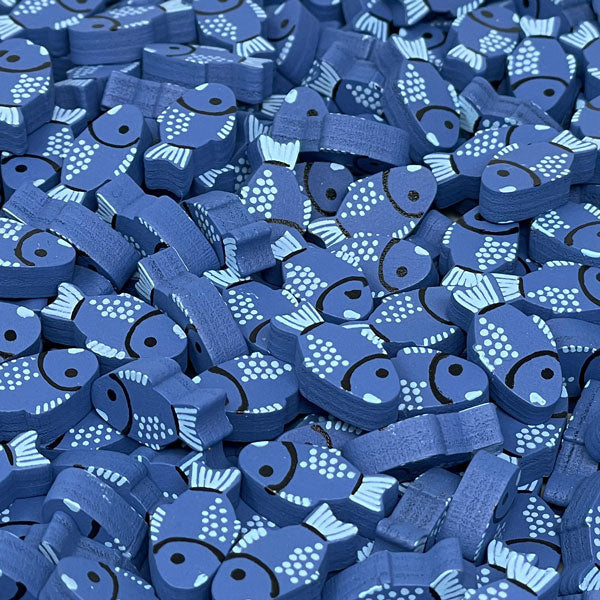 A photo of a pile of wooden fish tokens, painted with light blue and black details.