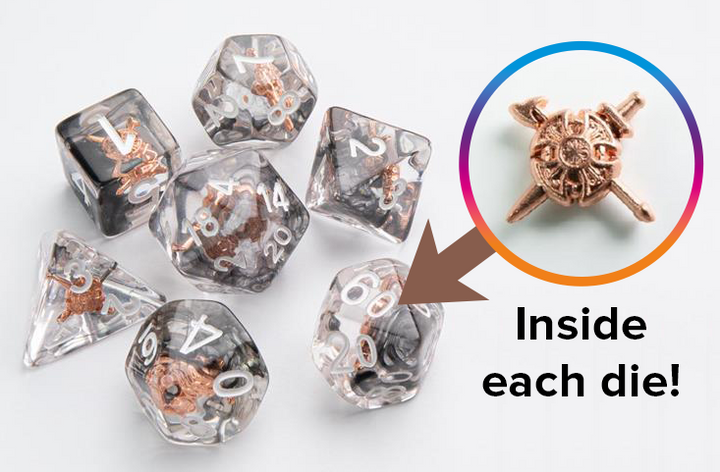 An overhead photo of seven Embraced Dice from Gamegenic, and a close up of a shield tokens with crossed swords behind it that is embedded in the center of each die.