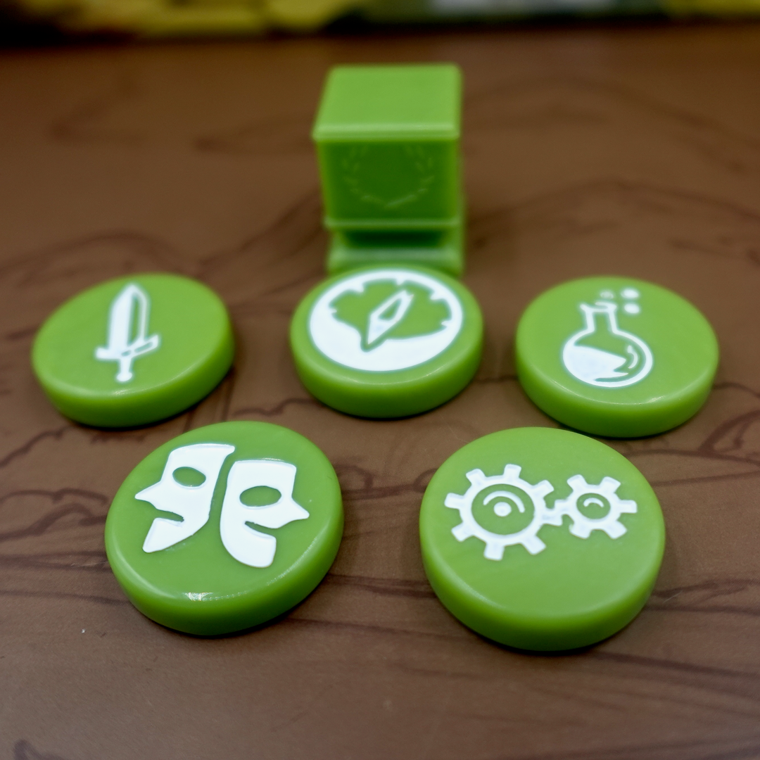 A close up photo of the green GeekUp tokens for use with the board game Tapestry.  Five of the bits are circular disks, each with an engraved symbol in the center. The remaining token is a square, plastic column with a laurel wreath printed on each side.