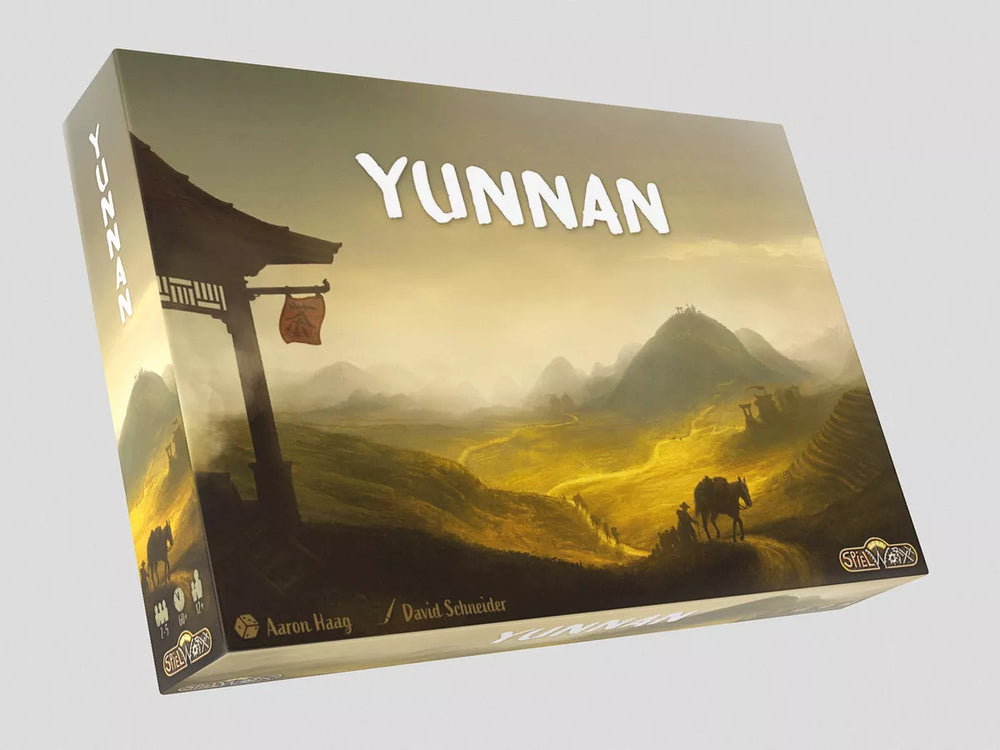 An angled view of the front cover of the board game Yunnan, featuring an illustration of foggy and hilly landscape, with a horse pulling a cart and the front corner of a building in the foreground.