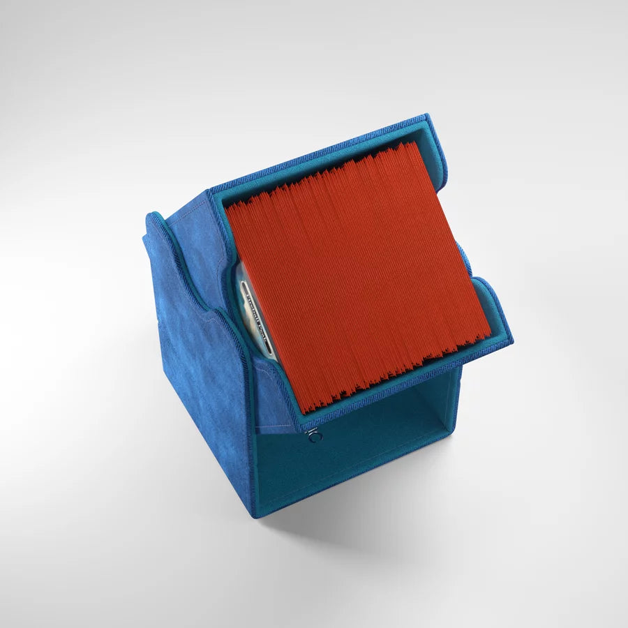 A photo of a blue, fabric box on a white background. The box is filled with cards and sitting at a steep angle, using the lid as a magnetic base.