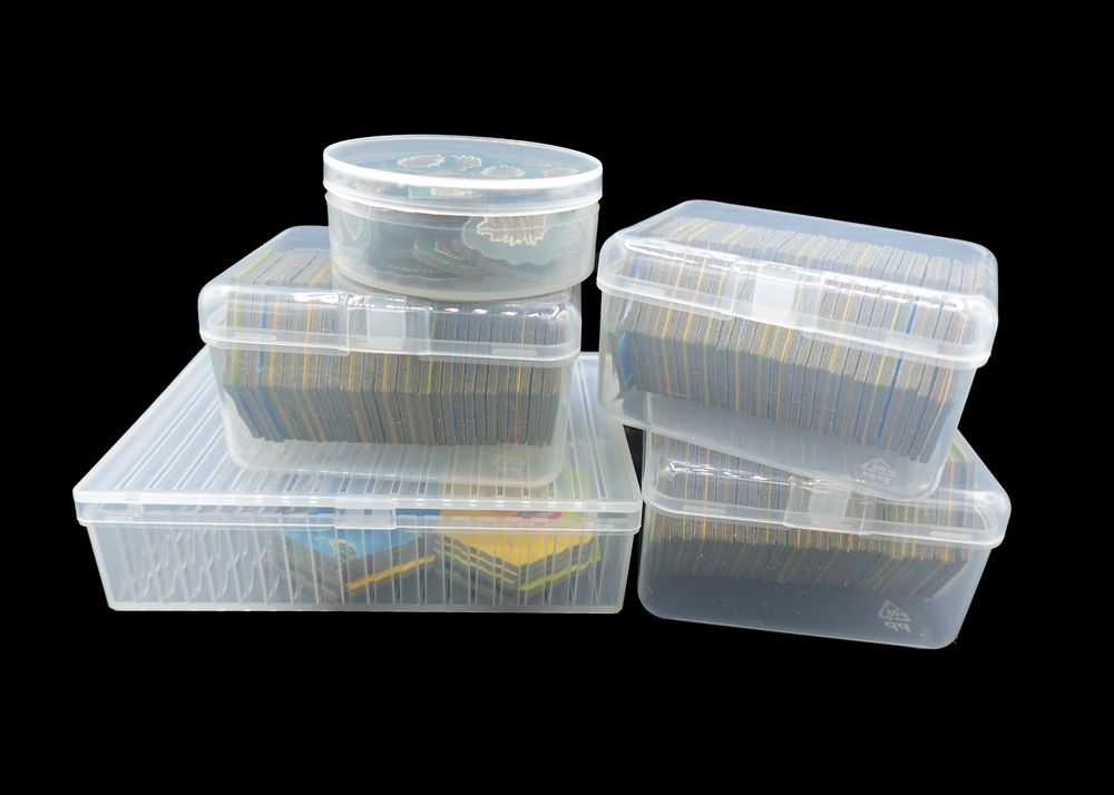 Set of clear plastic storage containers with lids on a black background