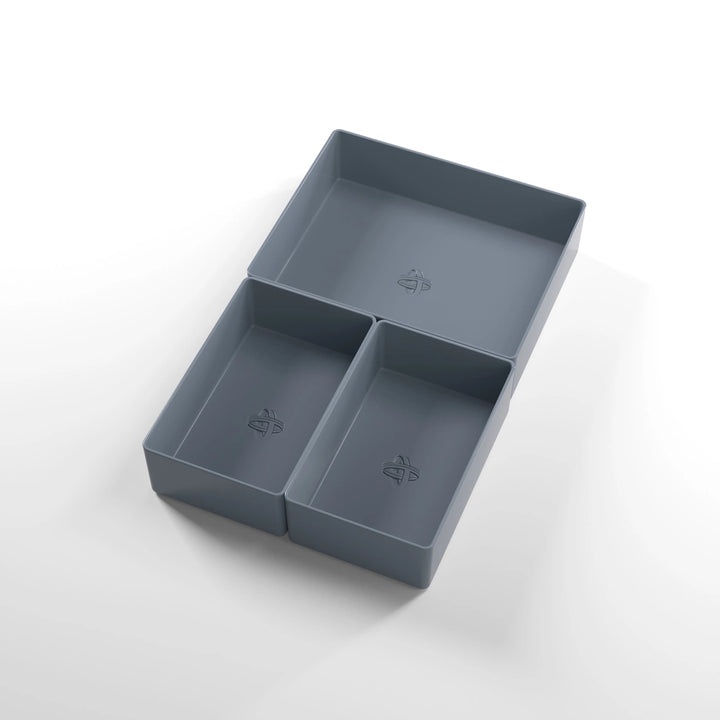 A photo of three, dark gray, plastic containers, two small and one large, on a white background.