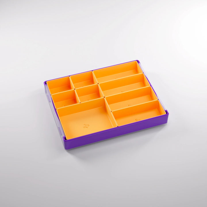 A photo of a empty, purple, plastic container on a white background. Inside of this container are smaller, orange sections of various sizes.