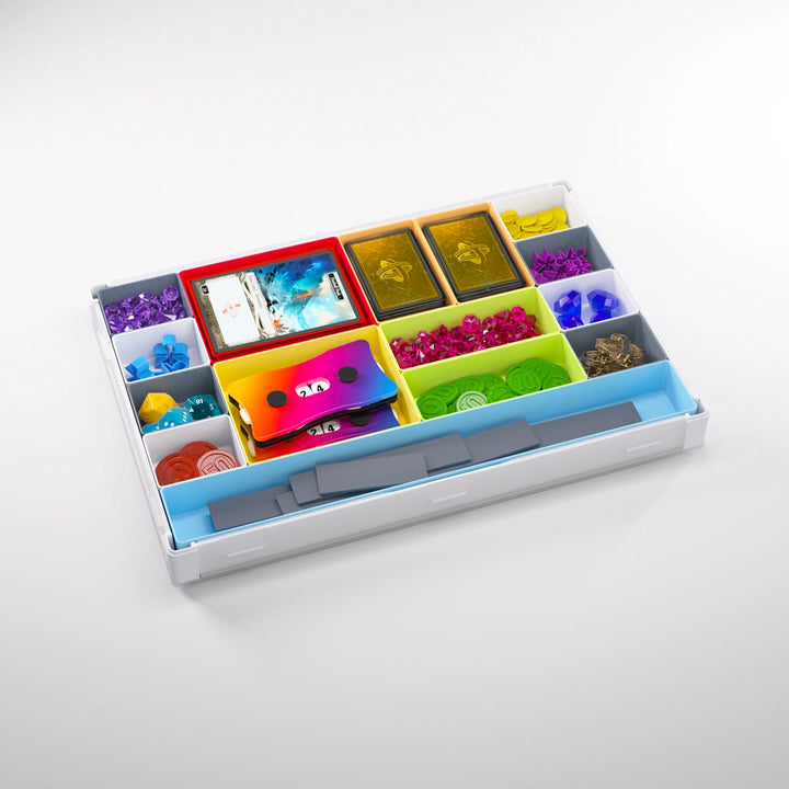 A photo of a white container, with many smaller, multicolored containers, each holding a variety of board game accessories and supplies. The lid is removed from the container and clipped to the bottom.