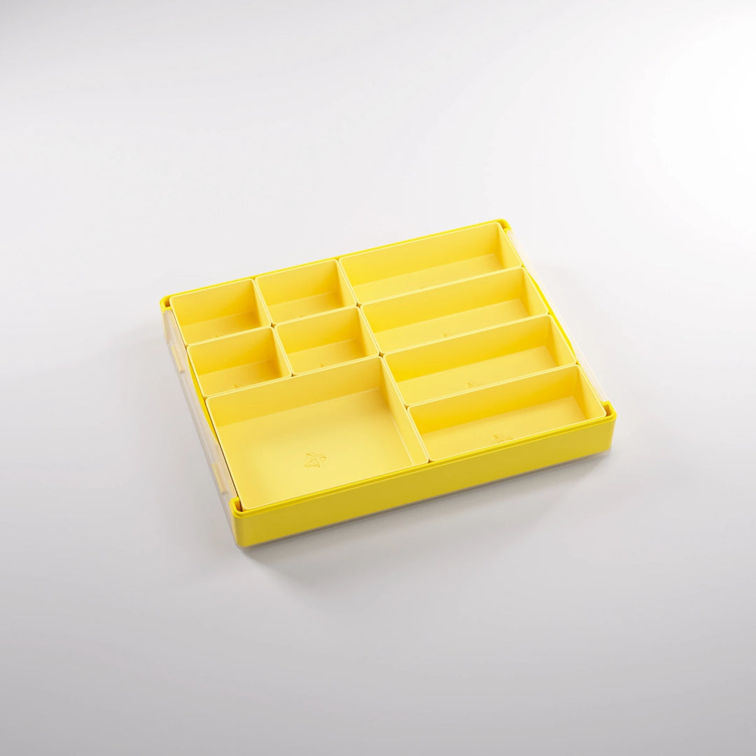 A photo of a empty, yellow, plastic container on a white background. Inside of this container are smaller sections of various sizes.