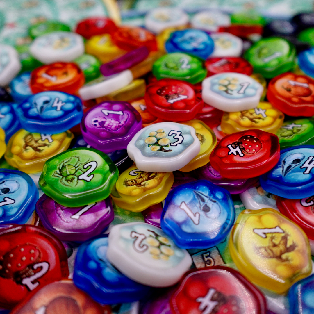 A photo of plastic, transparent upgrade tokens for use with the board game Quacks of Quedlinburg.