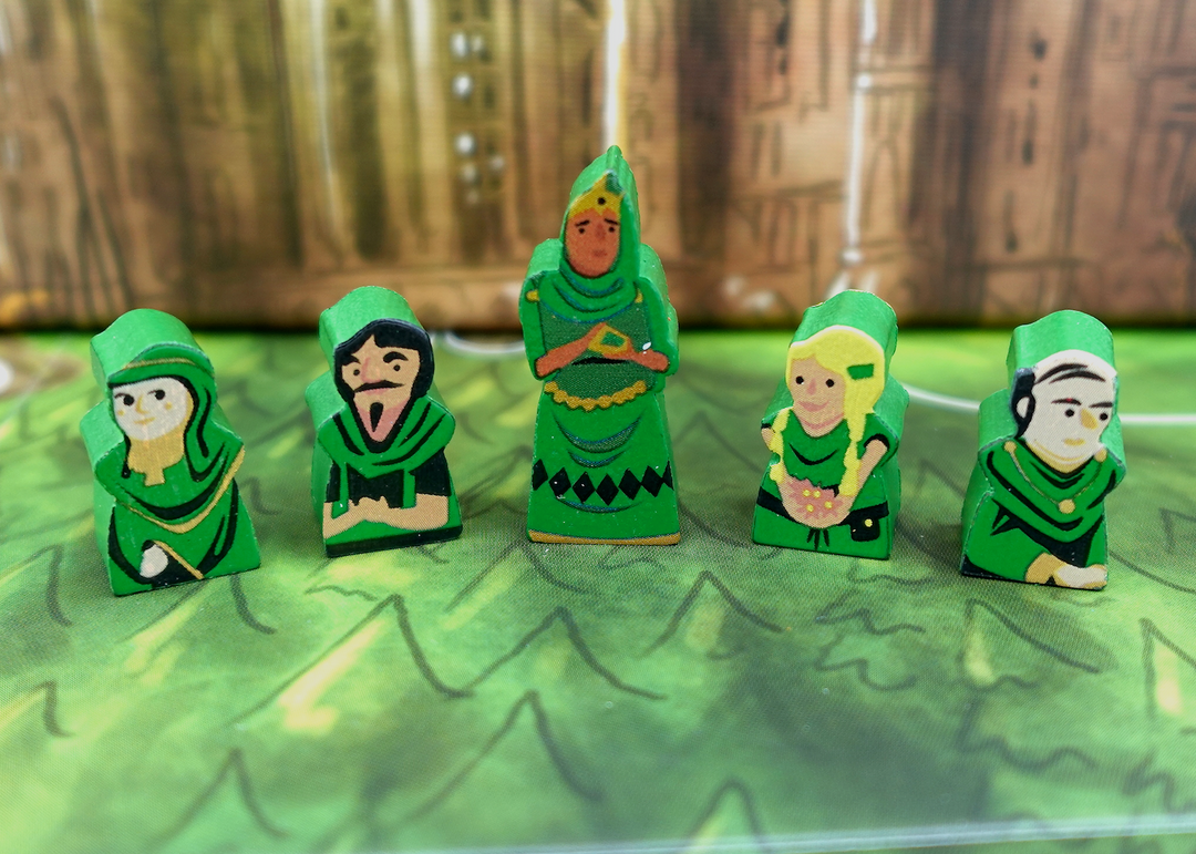 A close up photo of five wooden people tokens made from wood, with faces and clothes painted on one side, and the sides painted green.