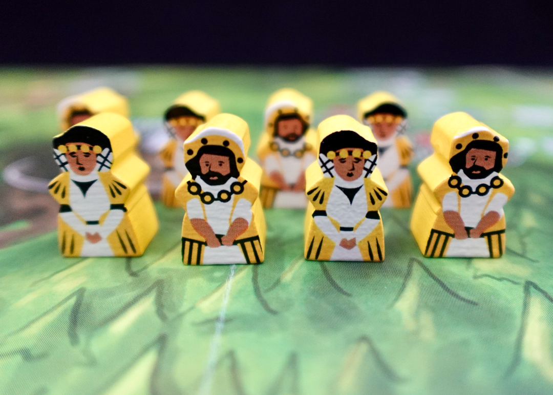 A closeup photo of wooden upgraded tokens for the board game Architects of the West Kingdom, made by Meeple Source, featuring yellow-painted wooden people in medieval style dress.