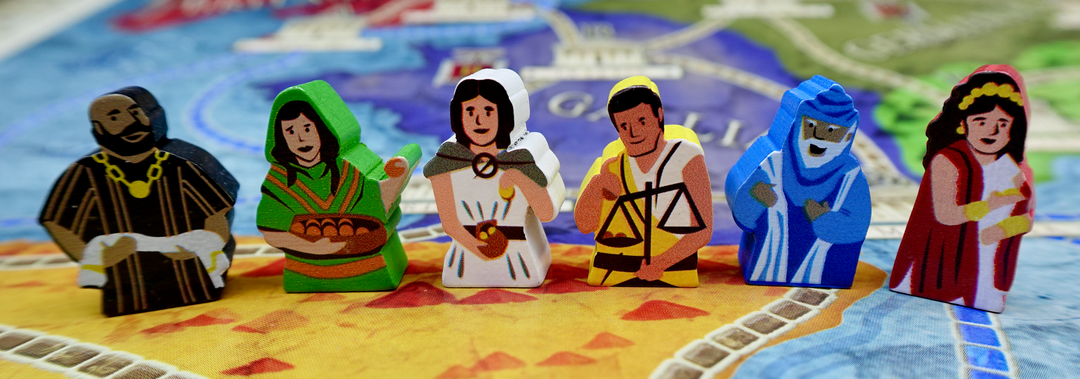 A pile of wooden tokens for use with the board game Concordia, featuring people with ancient Green clothing in a variety of painted colors