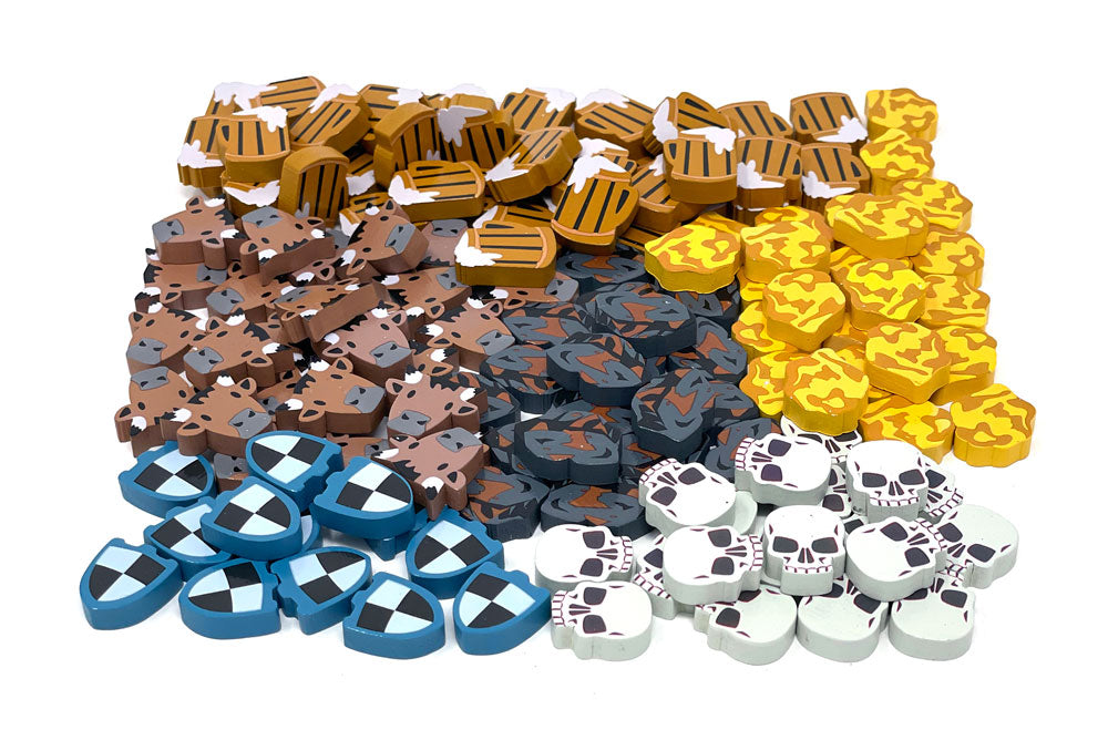 A pile of upgraded wooden tokens for use with the board game Raiders of the North Sea, featuring shields, skulls, gold, cow heads, tankards of beer, and weapons.