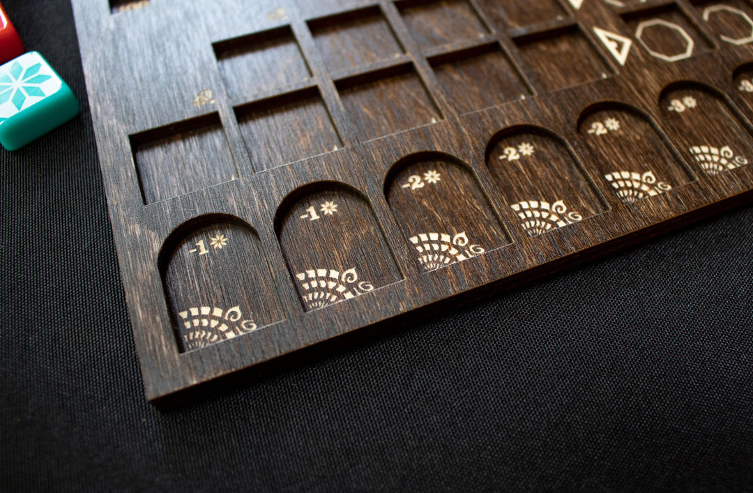 A closeup photo of a wooden player board for the board game Azul, created by Strata Strike, featuring laser cut mancala-style details in each carved recess.