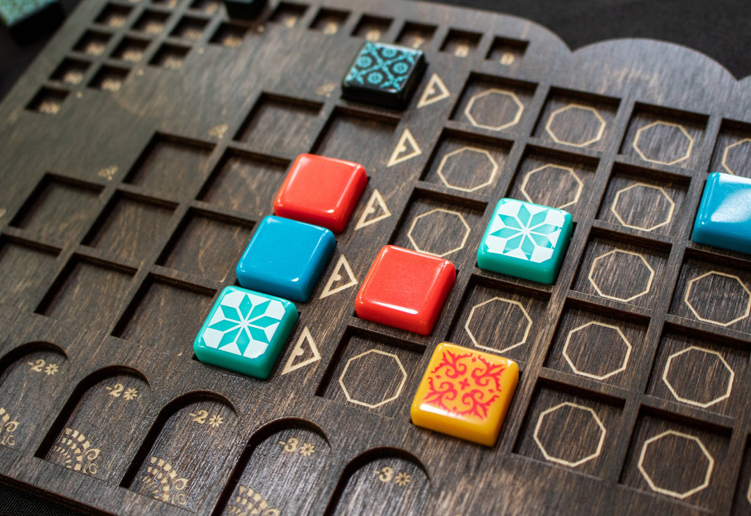 A closeup photo of a wooden player board for the board game Azul, created by Strata Strike, featuring the carved recesses holding the original game pieces within..