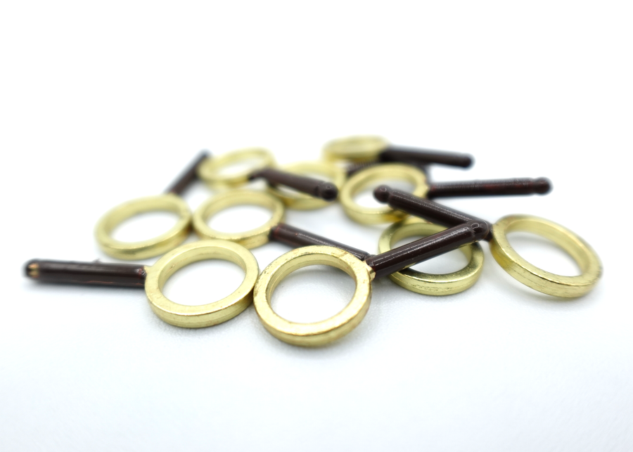 A close-up photo of a set of 10, resin magnifying glasses with painted brown handles and gold rims.