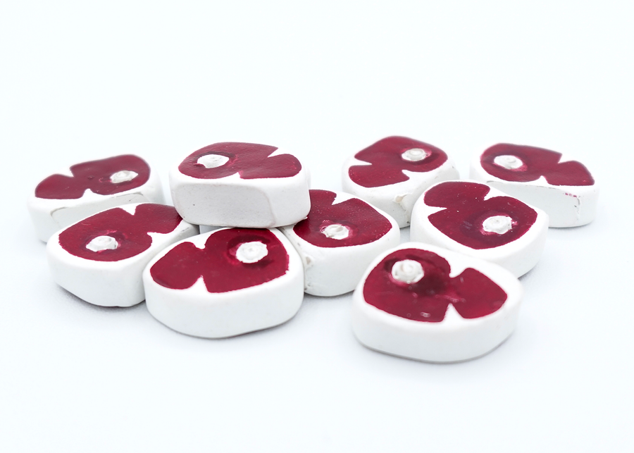 A close up photo of a group of tokens shaped and painted to look like raw slabs of meat, sitting on a white background.