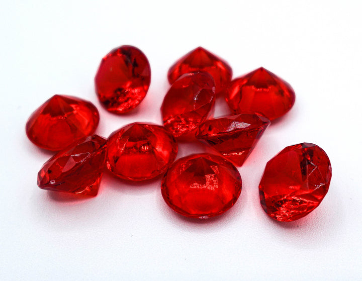 A photo of 10 red, transparent plastic gems on a white background.