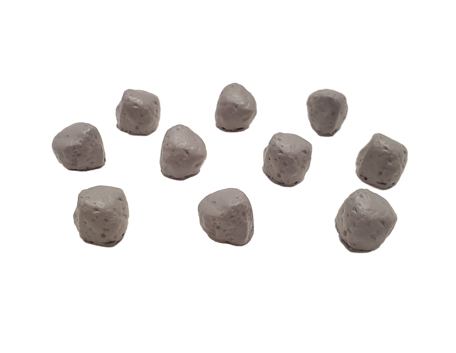 A close up photo of small, resin tokens, shaped and painted to look like small boulders, on a white background.
