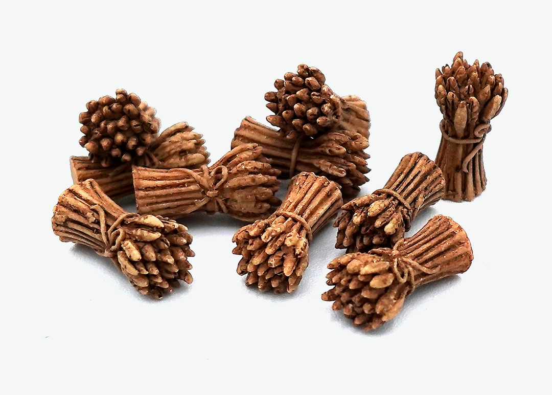A close up photo of a group of tokens shaped and painted to look like bundles of cut wheat tied together with rope, sitting on a white background.