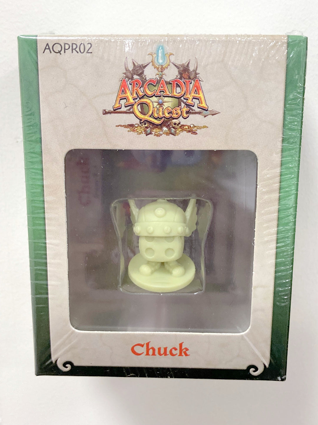 A picture of a plastic miniature character for use with the board game Arcadia Quest. This feature is labelled "Chuck" and is a six-sided die with shoes and wearing a horned Viking helmet.