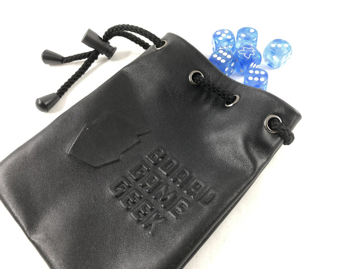 A black leather bag, embossed with the words "BoardGameGeek" and a logo, with a drawstring to the left and a tumble of light blue dice coming out of the bag at the top.