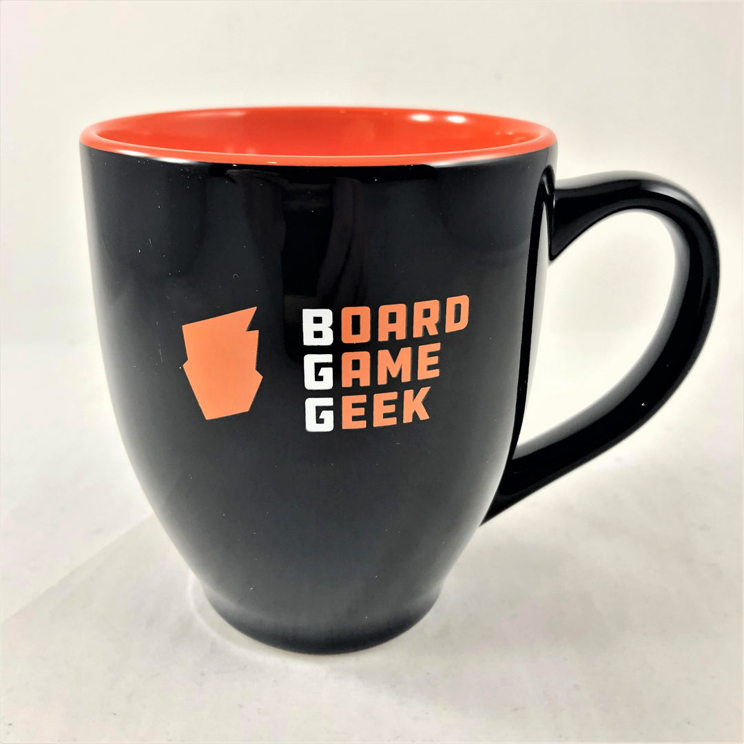 A bistro-shaped, glossy black coffee mug, with orange on the inside, labeled with "BoardGameGeek" on the outside, and on a white background.